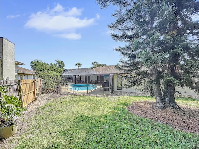 view of yard featuring a lanai, a patio area, fence, and a fenced in pool