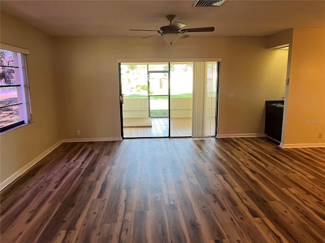 empty room featuring dark wood-type flooring and ceiling fan