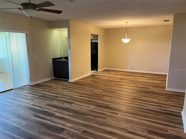 spare room with sink, dark wood-type flooring, a textured ceiling, and ceiling fan