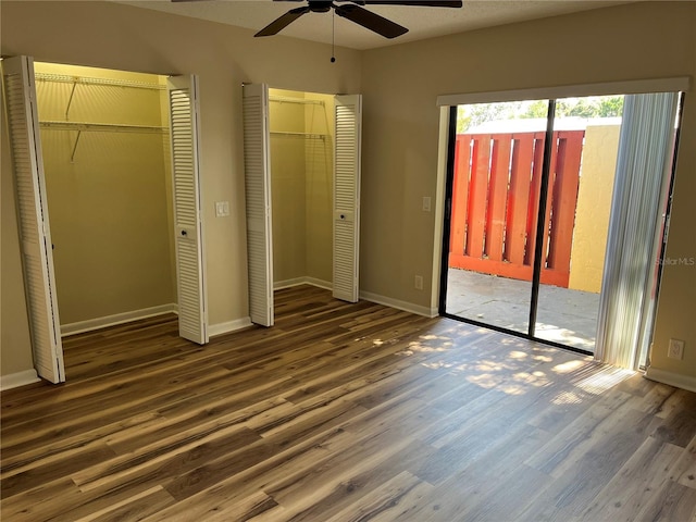 unfurnished bedroom with access to outside, dark hardwood / wood-style floors, and ceiling fan