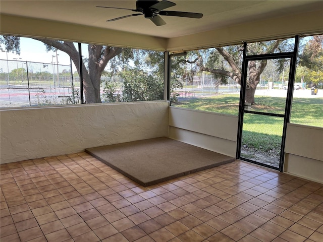 unfurnished sunroom with ceiling fan