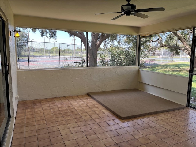 unfurnished sunroom with ceiling fan