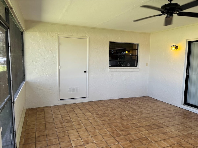 unfurnished sunroom featuring ceiling fan