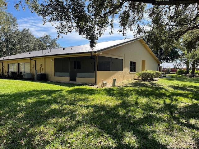 rear view of property with a yard and central AC