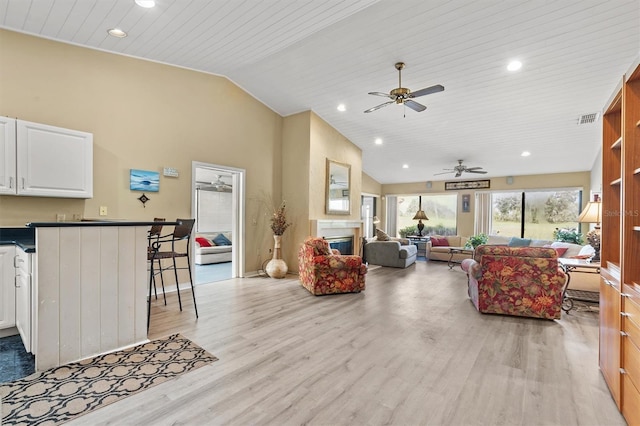 living room with ceiling fan, high vaulted ceiling, light hardwood / wood-style floors, and wooden ceiling