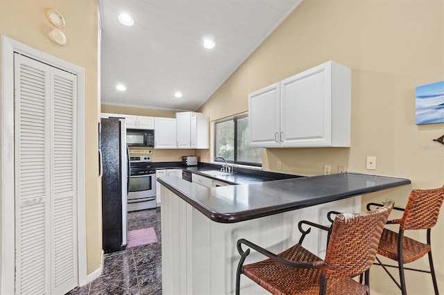 kitchen with white cabinetry, appliances with stainless steel finishes, a kitchen bar, and kitchen peninsula