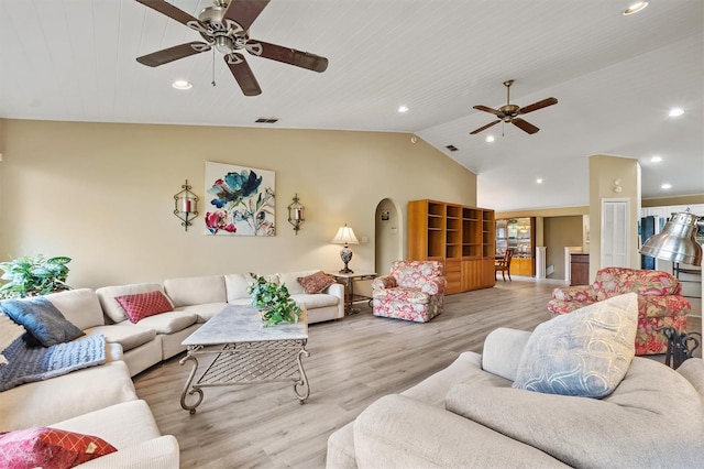 living room with ceiling fan, lofted ceiling, and light hardwood / wood-style flooring