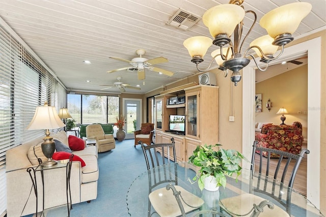 sunroom / solarium featuring ceiling fan with notable chandelier