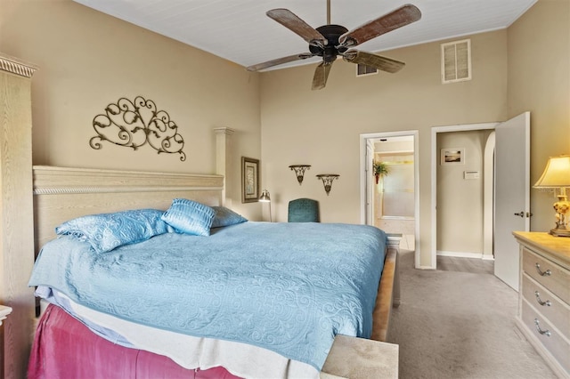 bedroom with ceiling fan, connected bathroom, and light carpet