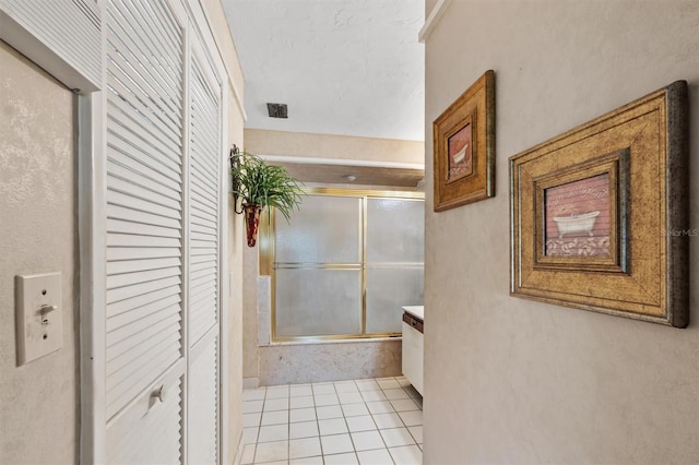 bathroom featuring tile patterned flooring, vanity, and enclosed tub / shower combo