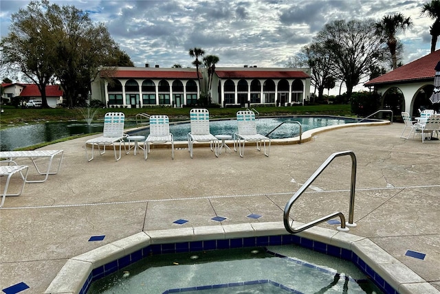 view of pool with a patio and a community hot tub