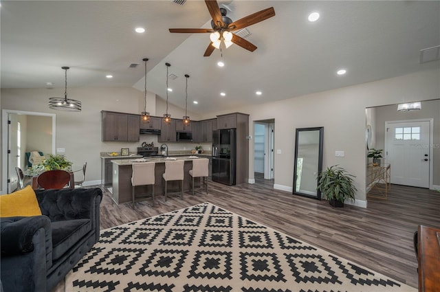 living room featuring dark wood-type flooring, ceiling fan, sink, and vaulted ceiling