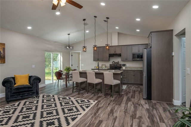 kitchen featuring a kitchen island with sink, stainless steel appliances, decorative light fixtures, and dark hardwood / wood-style flooring