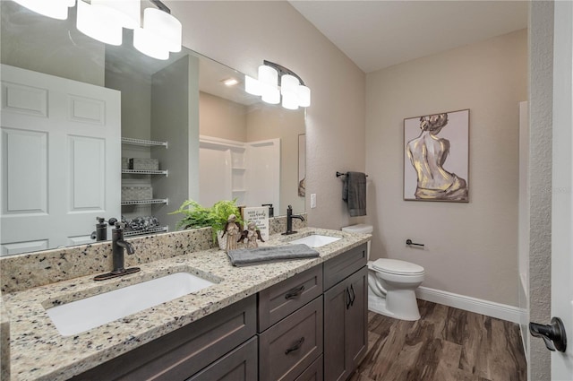 bathroom with hardwood / wood-style floors, vanity, and toilet