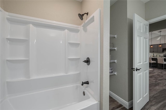 bathroom with hardwood / wood-style flooring and bathtub / shower combination