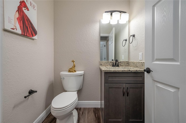 bathroom with wood-type flooring, vanity, and toilet