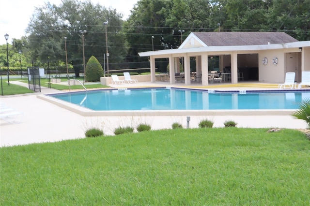 view of swimming pool with a patio and a lawn