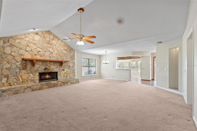 unfurnished living room with high vaulted ceiling, a stone fireplace, carpet flooring, and ceiling fan with notable chandelier