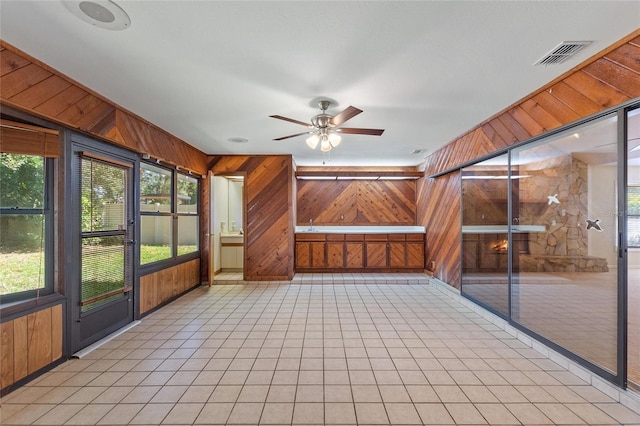 unfurnished sunroom with a healthy amount of sunlight and ceiling fan