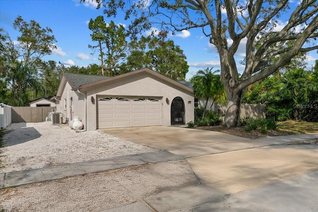 view of front of property featuring a garage and cooling unit