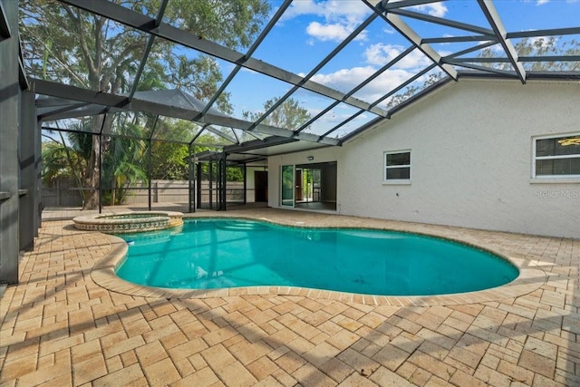 view of pool with an in ground hot tub, a patio, and glass enclosure