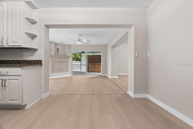 kitchen featuring backsplash, white cabinets, light hardwood / wood-style floors, and ceiling fan