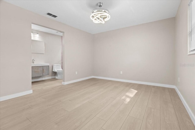 empty room featuring sink and light hardwood / wood-style floors