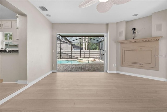 unfurnished living room with light hardwood / wood-style floors and ceiling fan