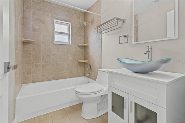 full bathroom with vanity, toilet, tiled shower / bath combo, and wood-type flooring