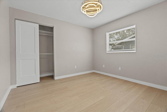 unfurnished bedroom with a closet and light hardwood / wood-style floors