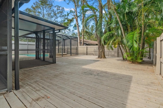 wooden terrace with a lanai and a fenced in pool