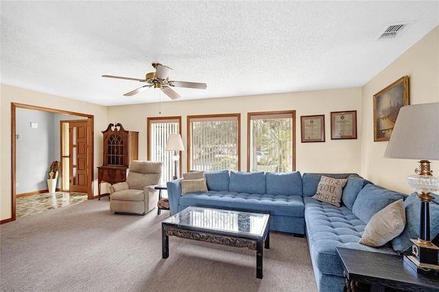 living room featuring a textured ceiling, ceiling fan, and carpet