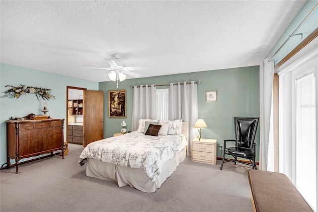 bedroom with ceiling fan, light carpet, and a textured ceiling