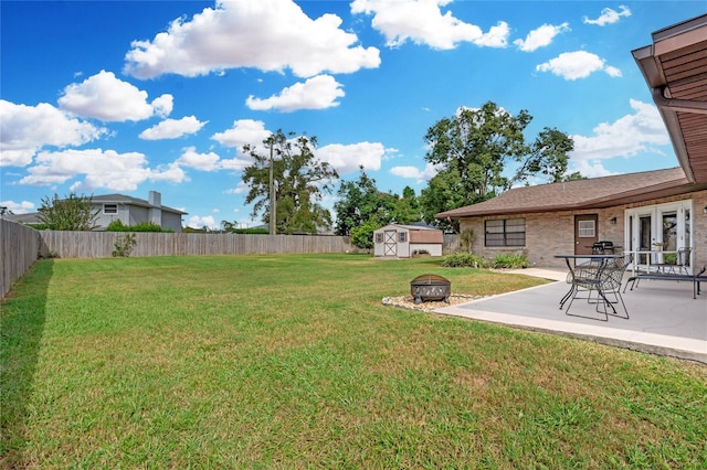 view of yard featuring an outdoor fire pit, a patio area, and a storage shed