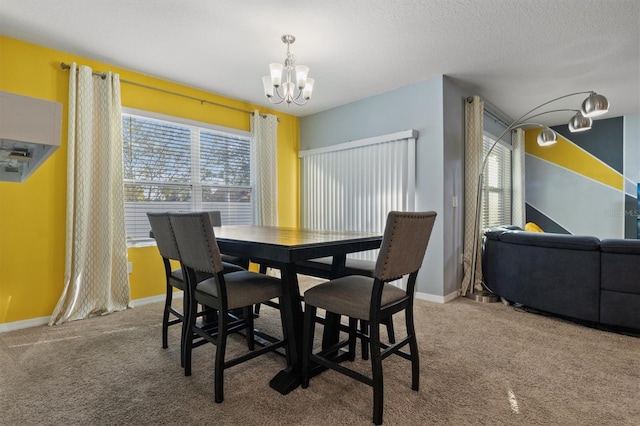 dining room featuring a textured ceiling, a chandelier, and carpet