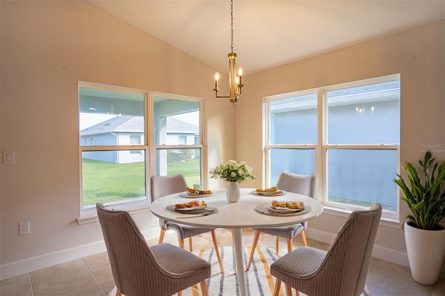 tiled dining room featuring lofted ceiling and a chandelier
