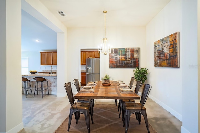 dining room with a notable chandelier, sink, and carpet