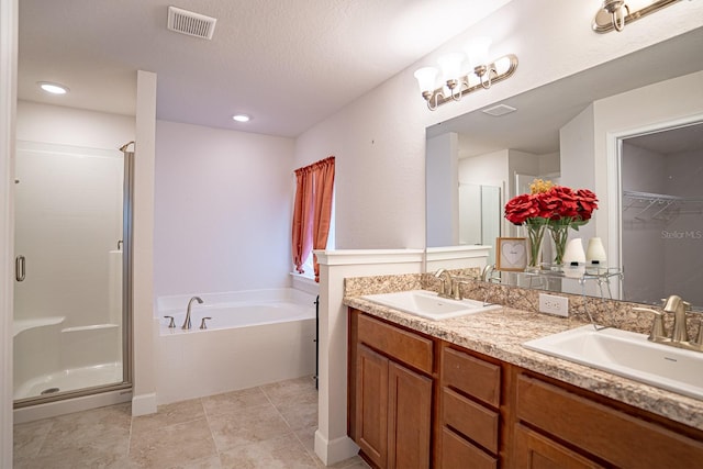 bathroom with vanity, independent shower and bath, a textured ceiling, and tile patterned flooring