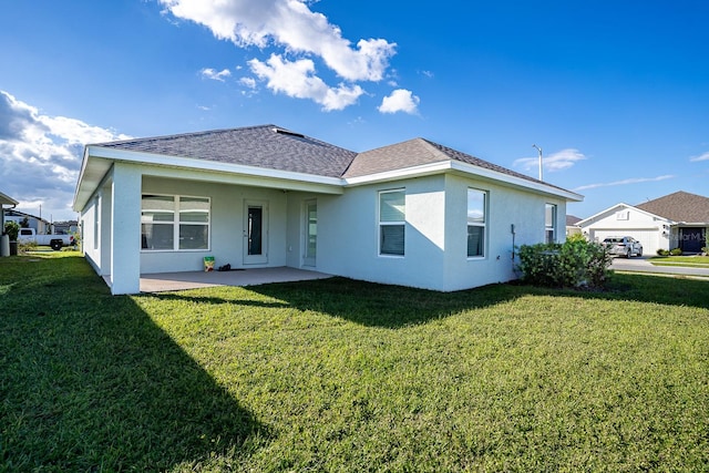 back of house with a garage and a lawn