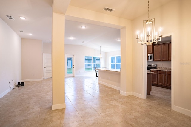 kitchen featuring a chandelier, appliances with stainless steel finishes, hanging light fixtures, and vaulted ceiling