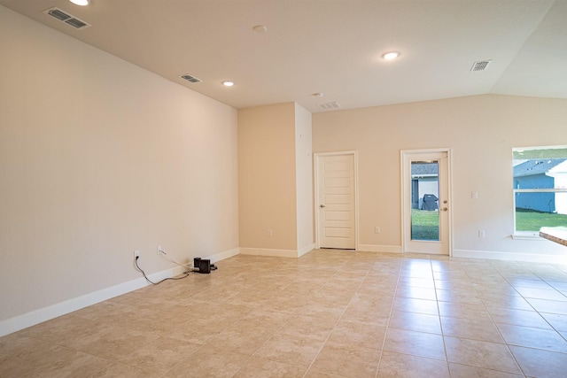 tiled spare room with lofted ceiling