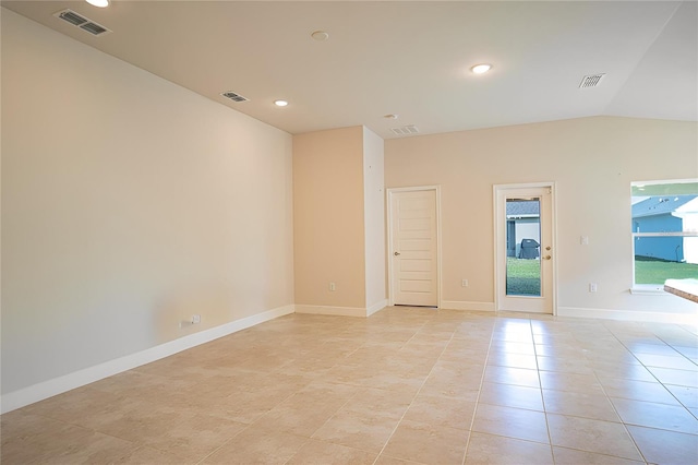tiled spare room with vaulted ceiling