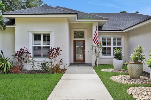 property entrance with a lawn