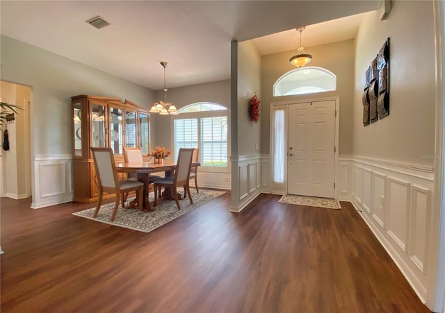 entrance foyer with an inviting chandelier and dark hardwood / wood-style floors