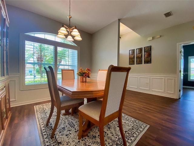 dining area with dark wood-type flooring and a chandelier