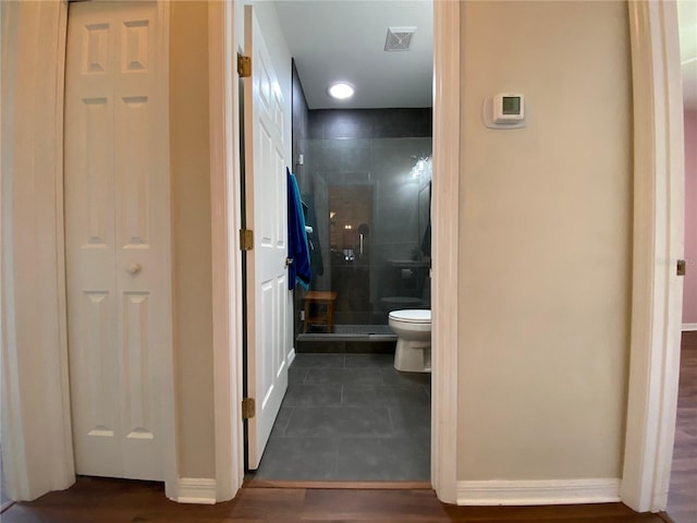 bathroom with hardwood / wood-style flooring, toilet, and an enclosed shower