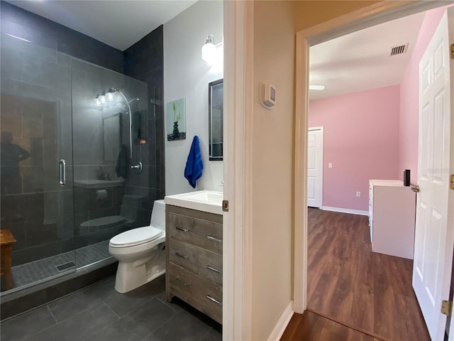 bathroom with vanity, toilet, wood-type flooring, and a shower with shower door