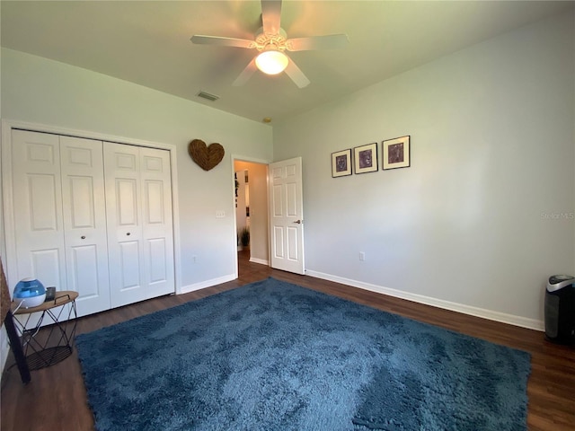 unfurnished bedroom featuring dark hardwood / wood-style flooring, a closet, and ceiling fan