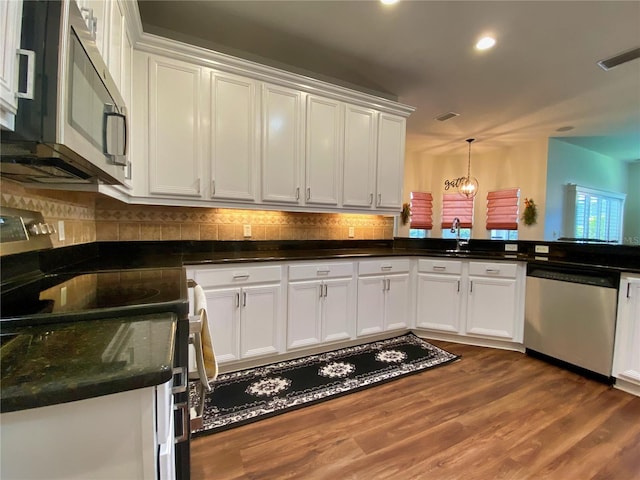 kitchen with appliances with stainless steel finishes, white cabinets, and dark hardwood / wood-style floors