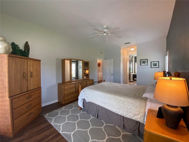 bedroom with dark wood-type flooring, ceiling fan, and ensuite bath